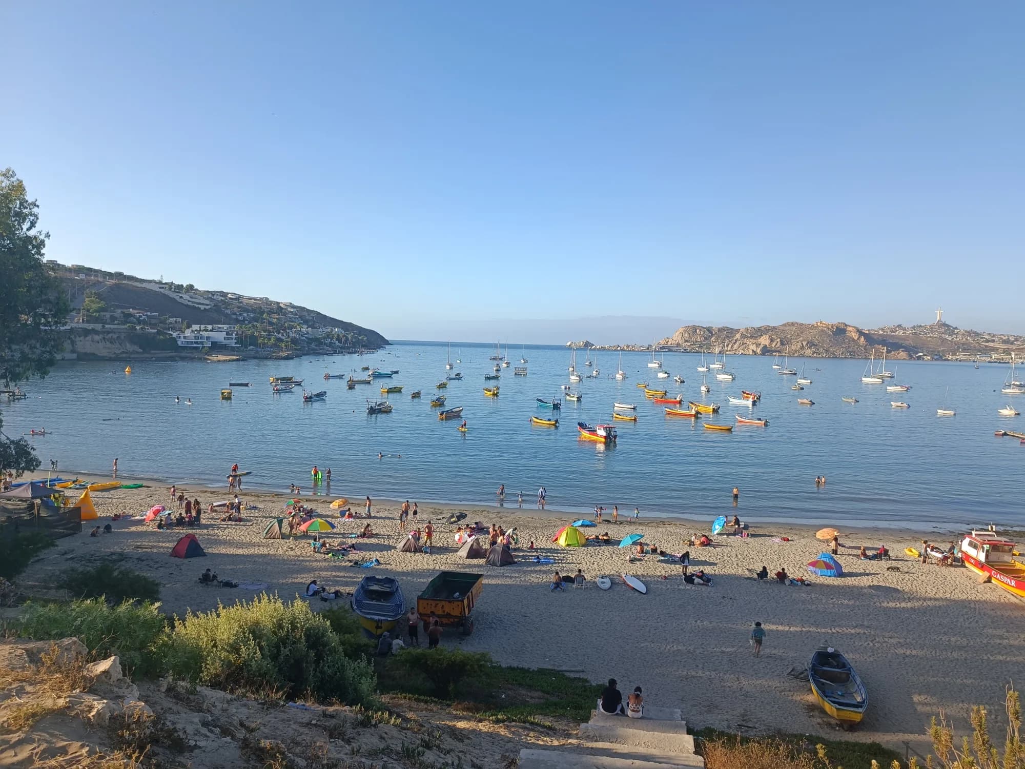 El mar y las embarcaciones de la bahía de La Herradura, con la Cruz del Tercer Milenio al fondo